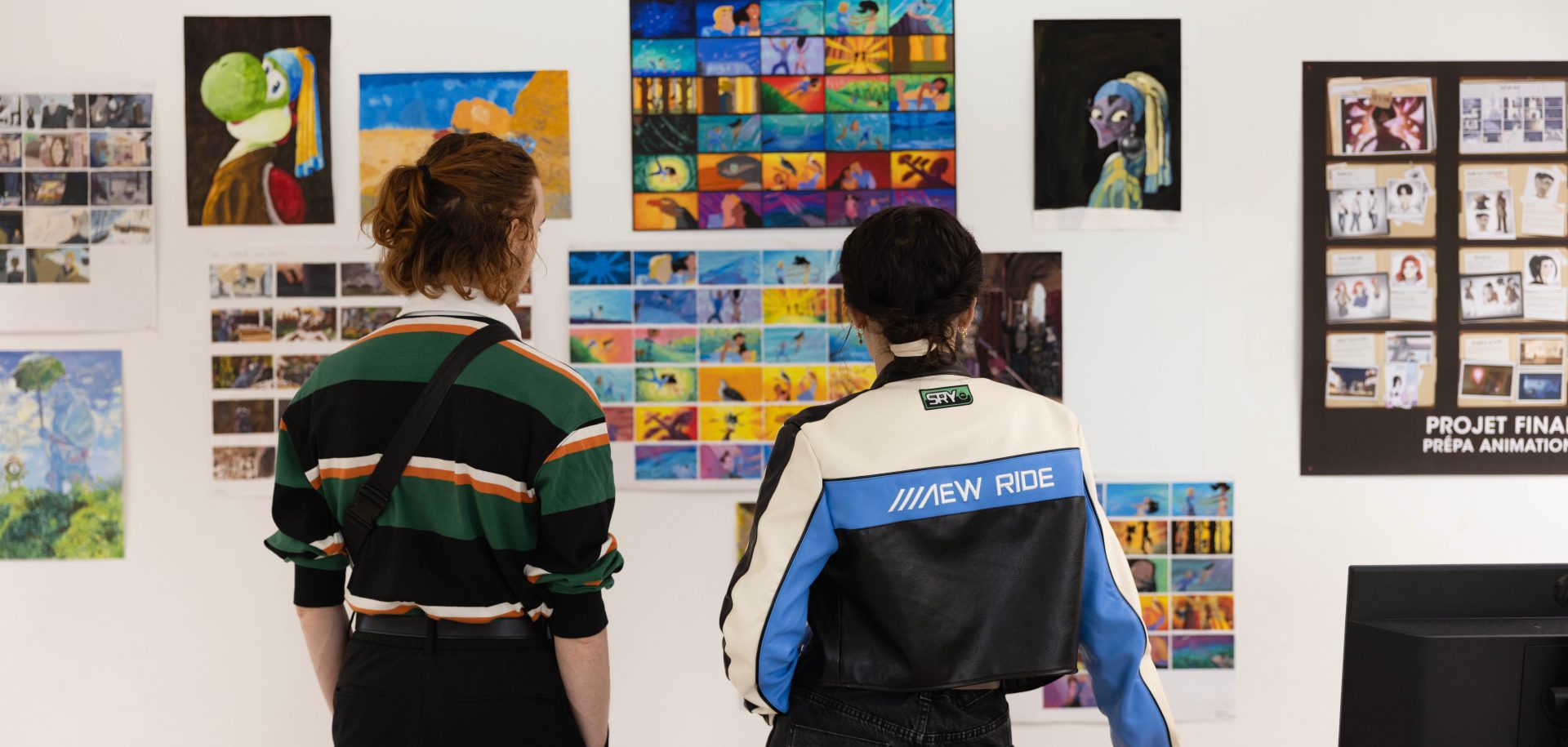 Deux étudiants admirant une exposition de travaux à l'occasion d'une journée portes ouvertes