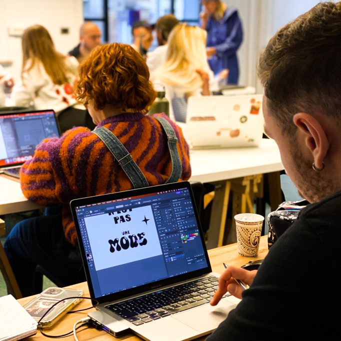 Plusieurs étudiants derrière leur écran en train de travailler sur les logiciels graphiques