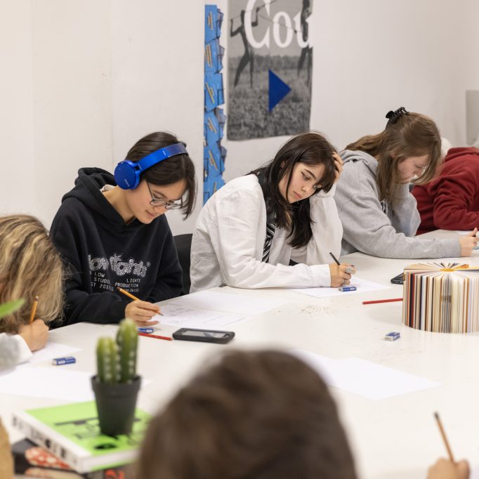 Des étudiants en salle de cours en train de dessiner.